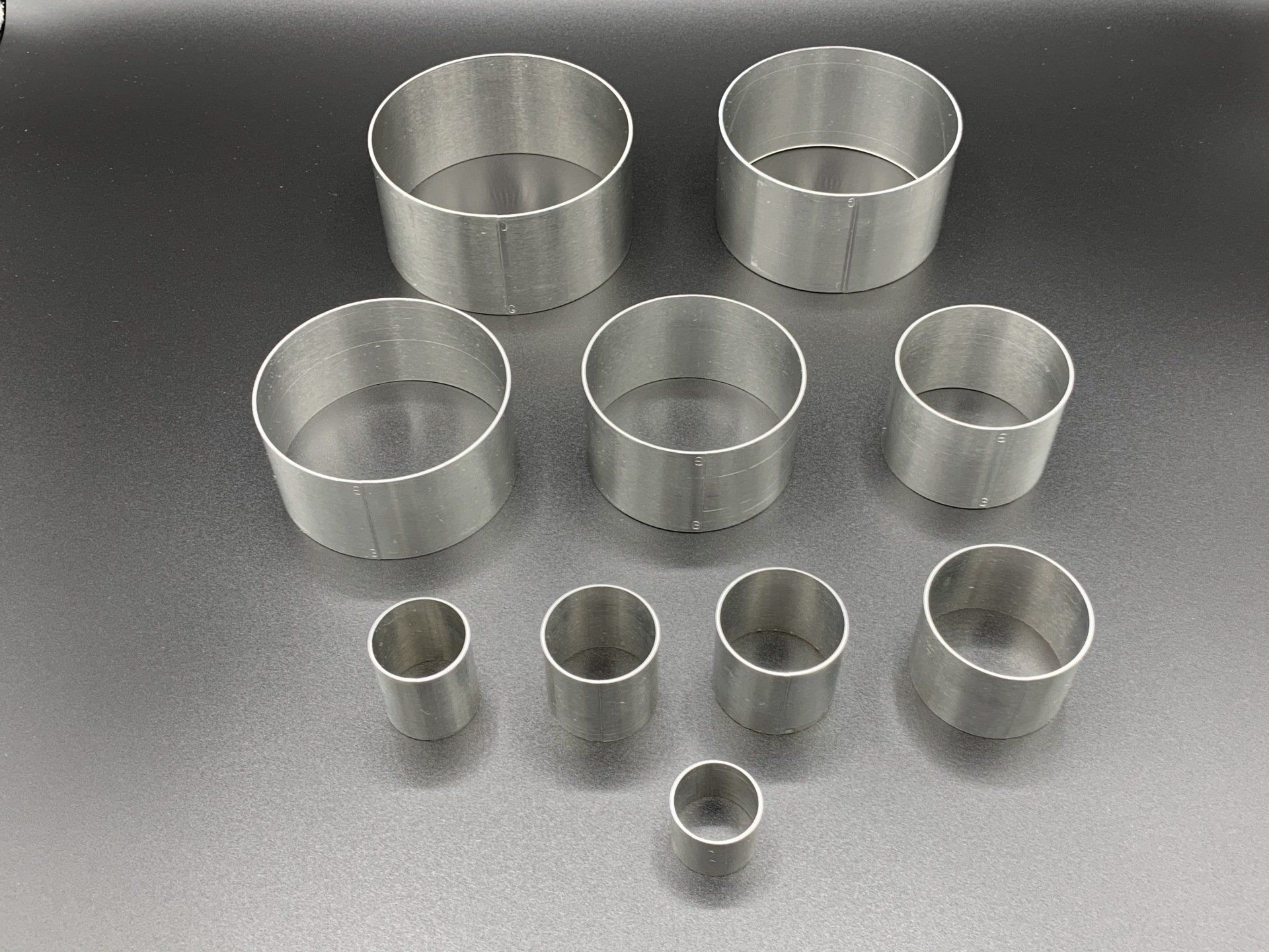 A group of stainless steel circles of different sizes are sitting on a table.