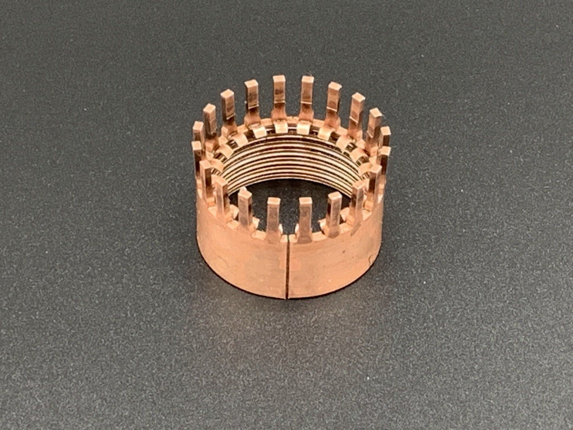 A copper ring is sitting on a gray surface