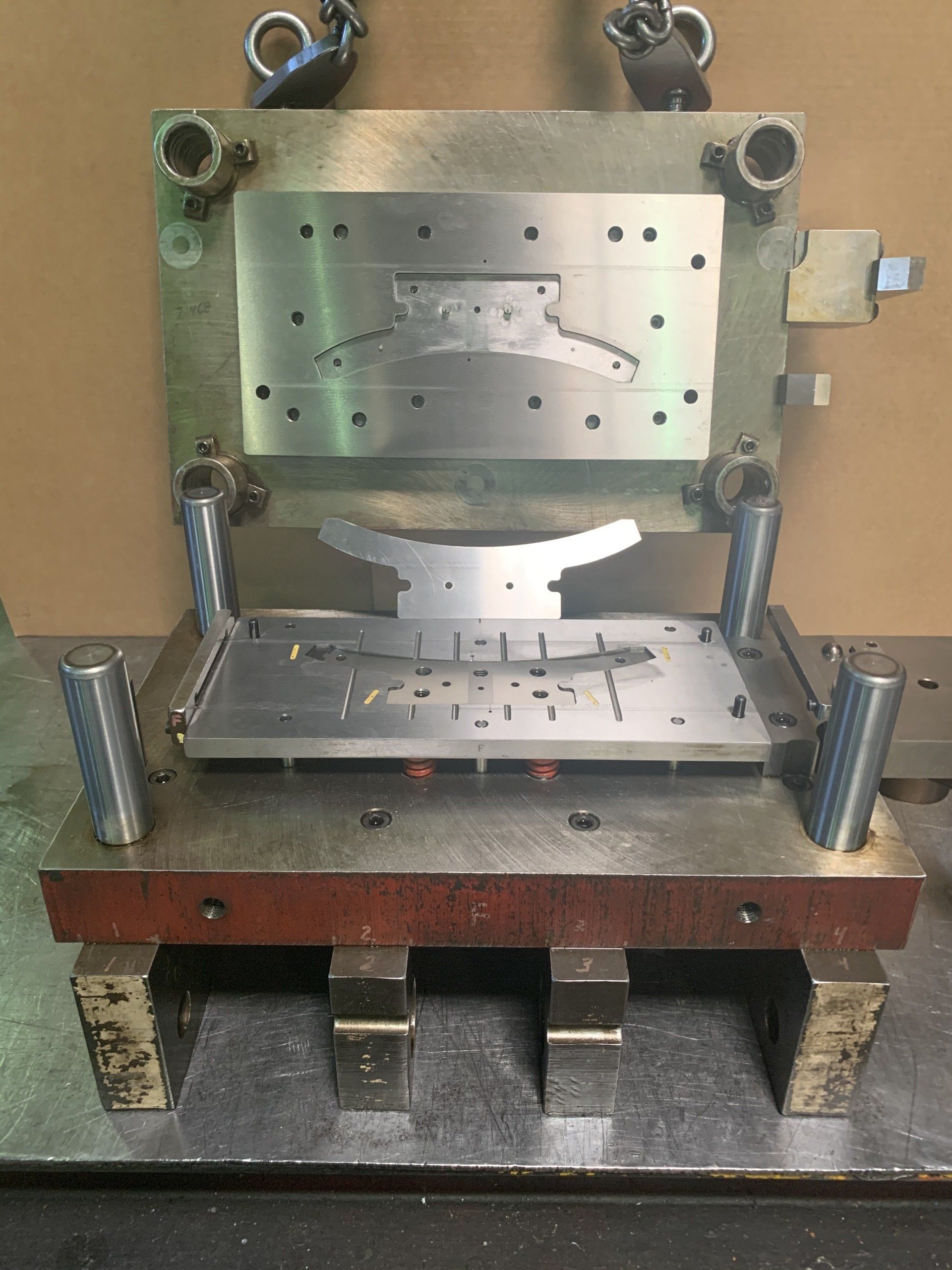 A metal mould is sitting on top of a metal table.