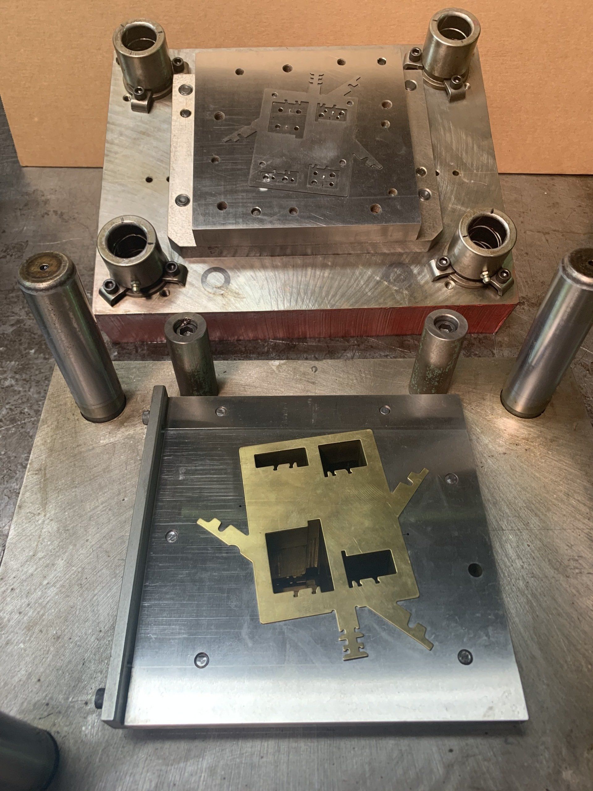 A metal mould with a picture of a house on it is sitting on a table.