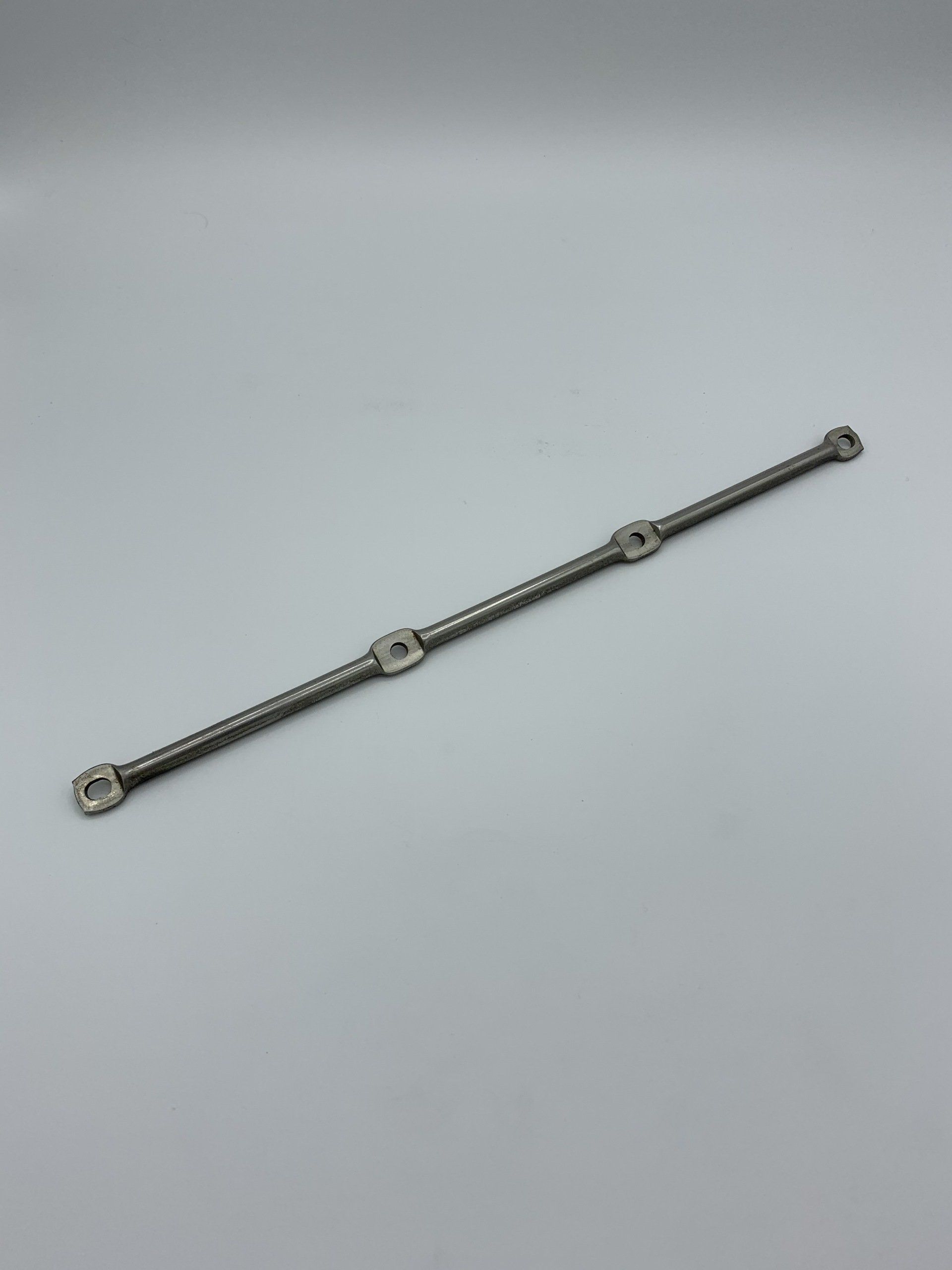 A silver bracelet is sitting on a white surface.