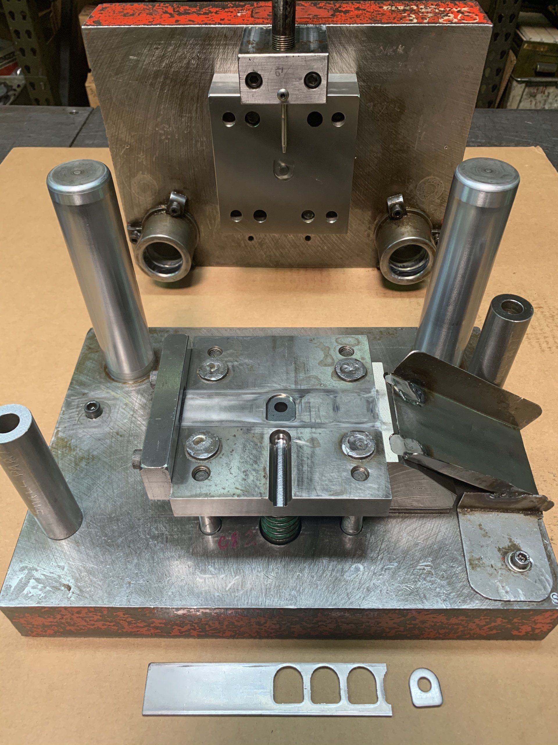 A metal mould is sitting on top of a wooden table.