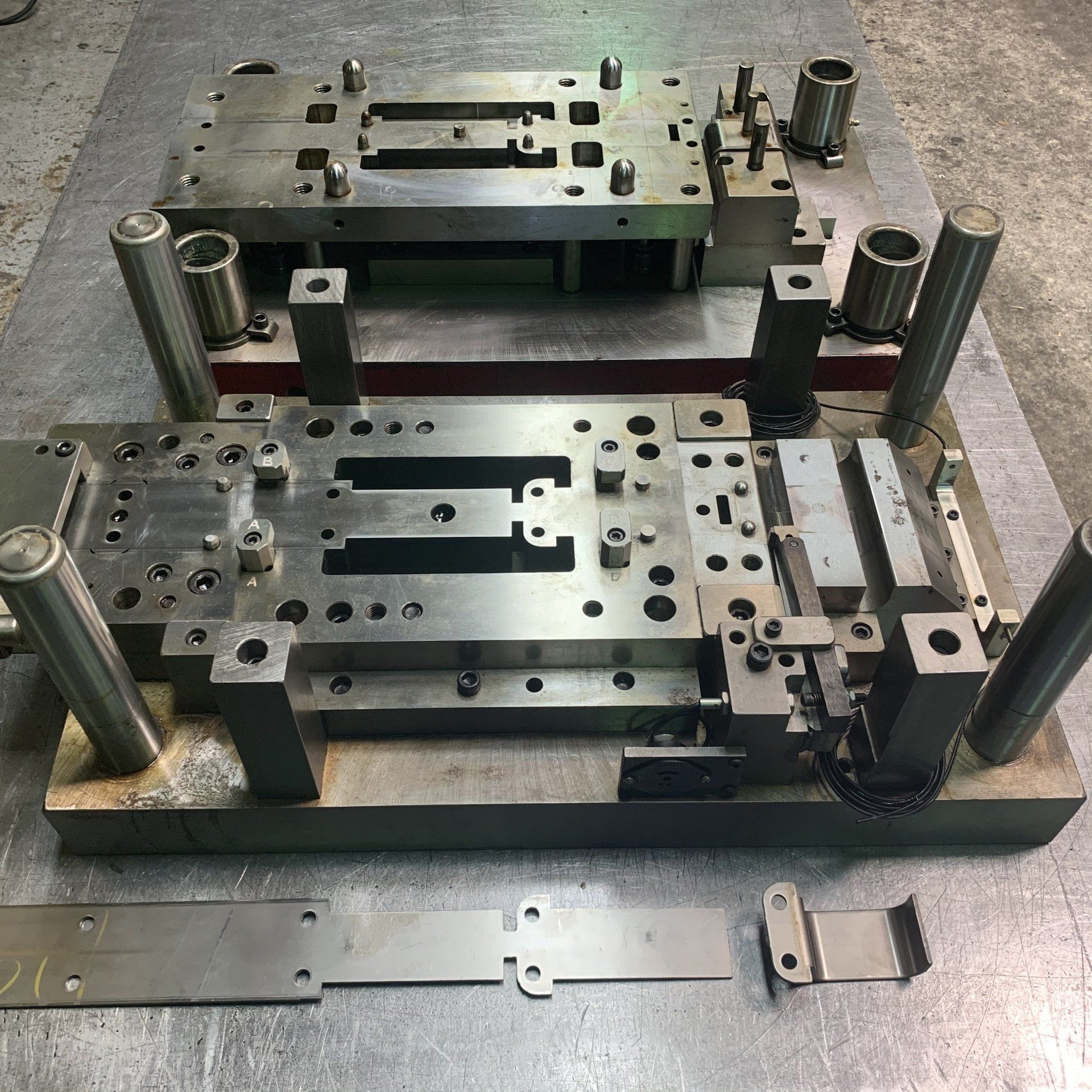 A metal mould is sitting on top of a metal table.