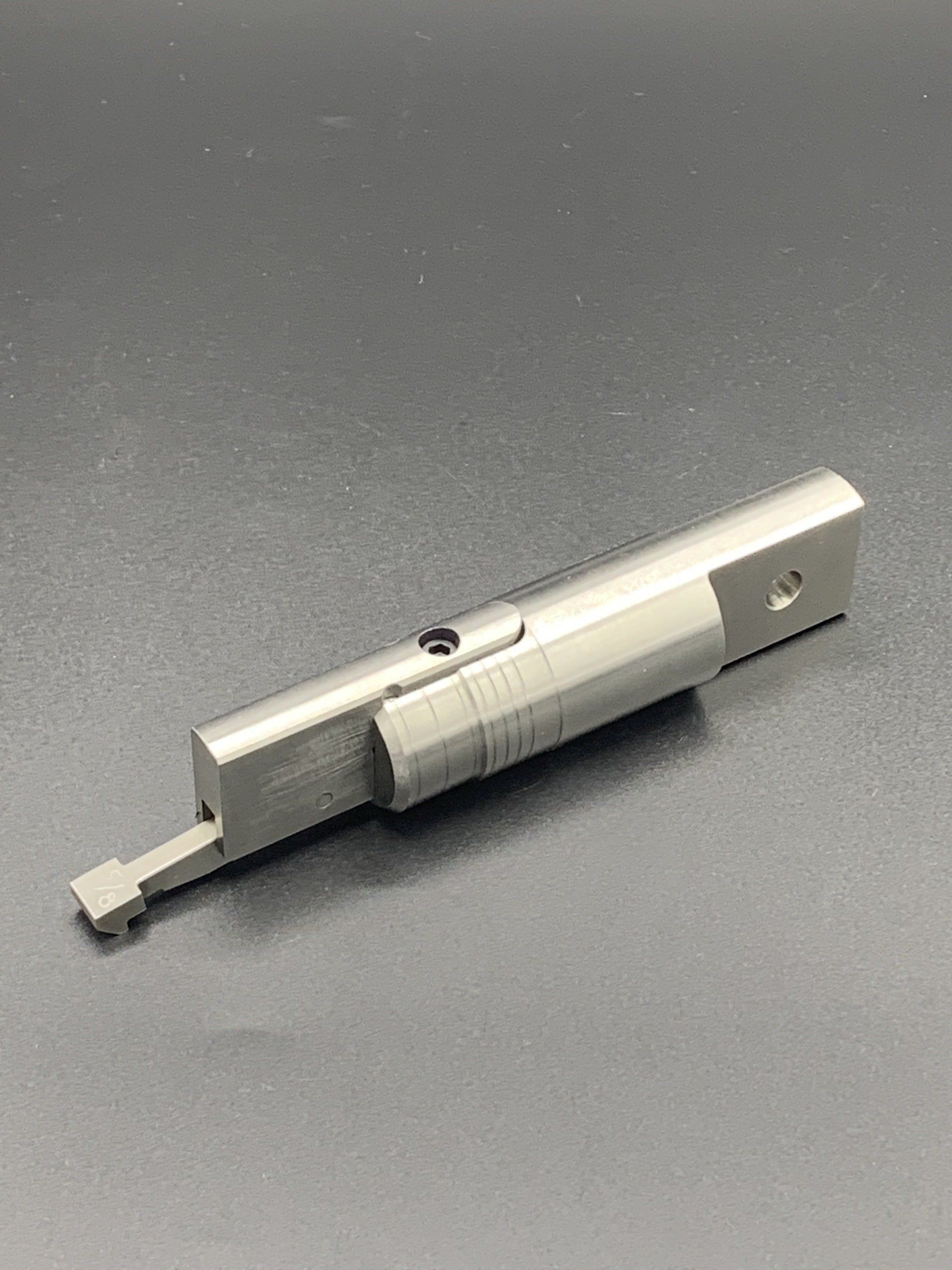 A metal object is sitting on top of a gray surface.