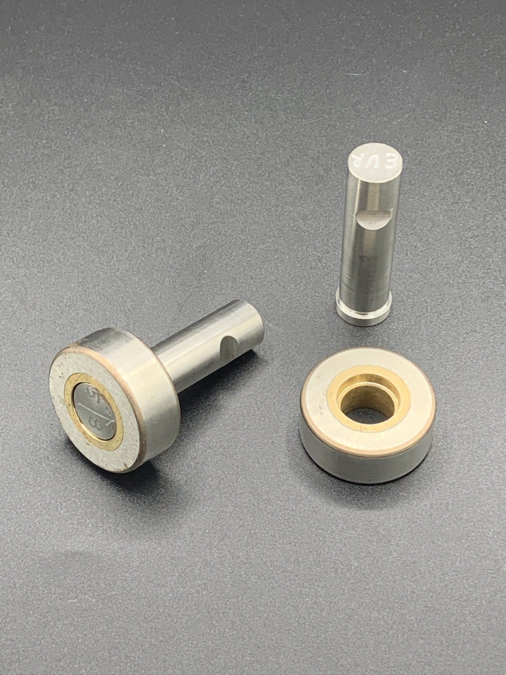 A close up of three metal parts on a table.