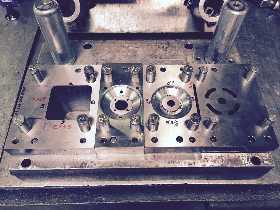 A metal mould with a hole in the middle is sitting on a table.