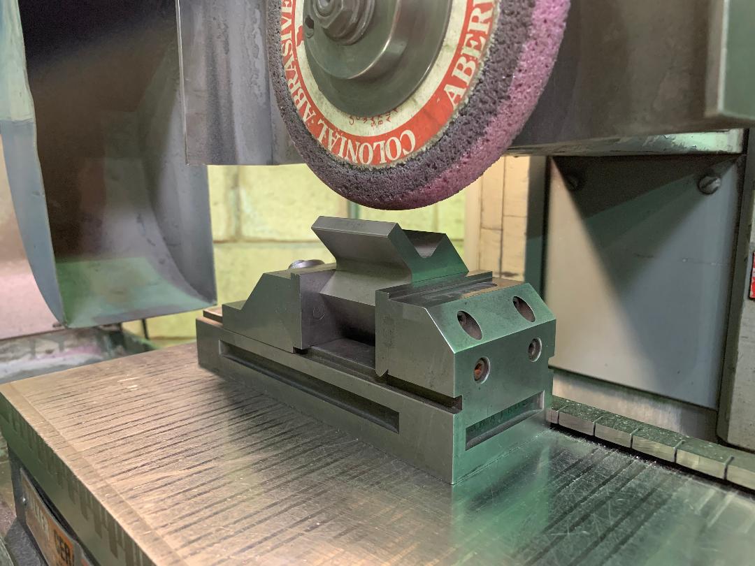 A machine is grinding a piece of metal on a table.