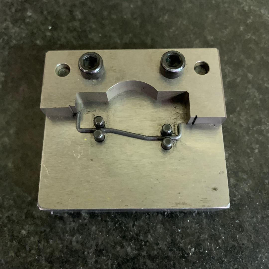 A piece of metal with holes in it is sitting on a table.