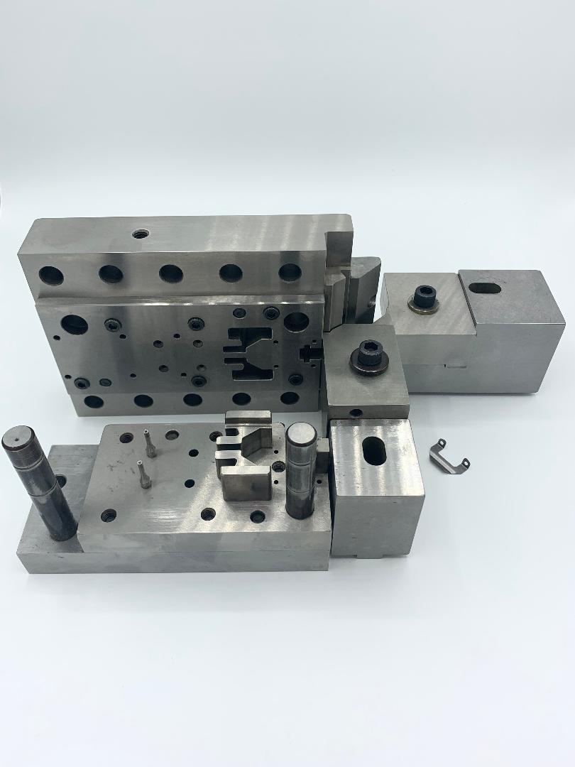 A couple of metal pieces sitting on top of each other on a white surface.