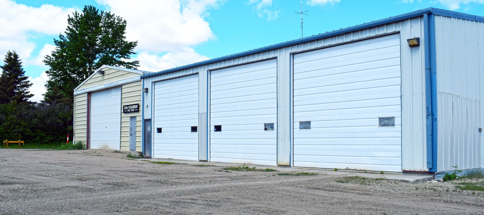 A row of white garage doors are lined up in a parking lot.