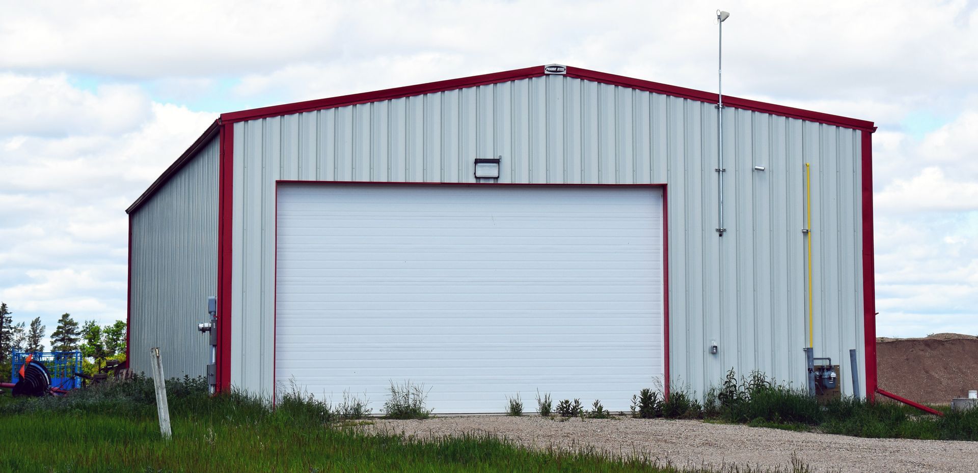 A white building with a red trim and a white garage door.