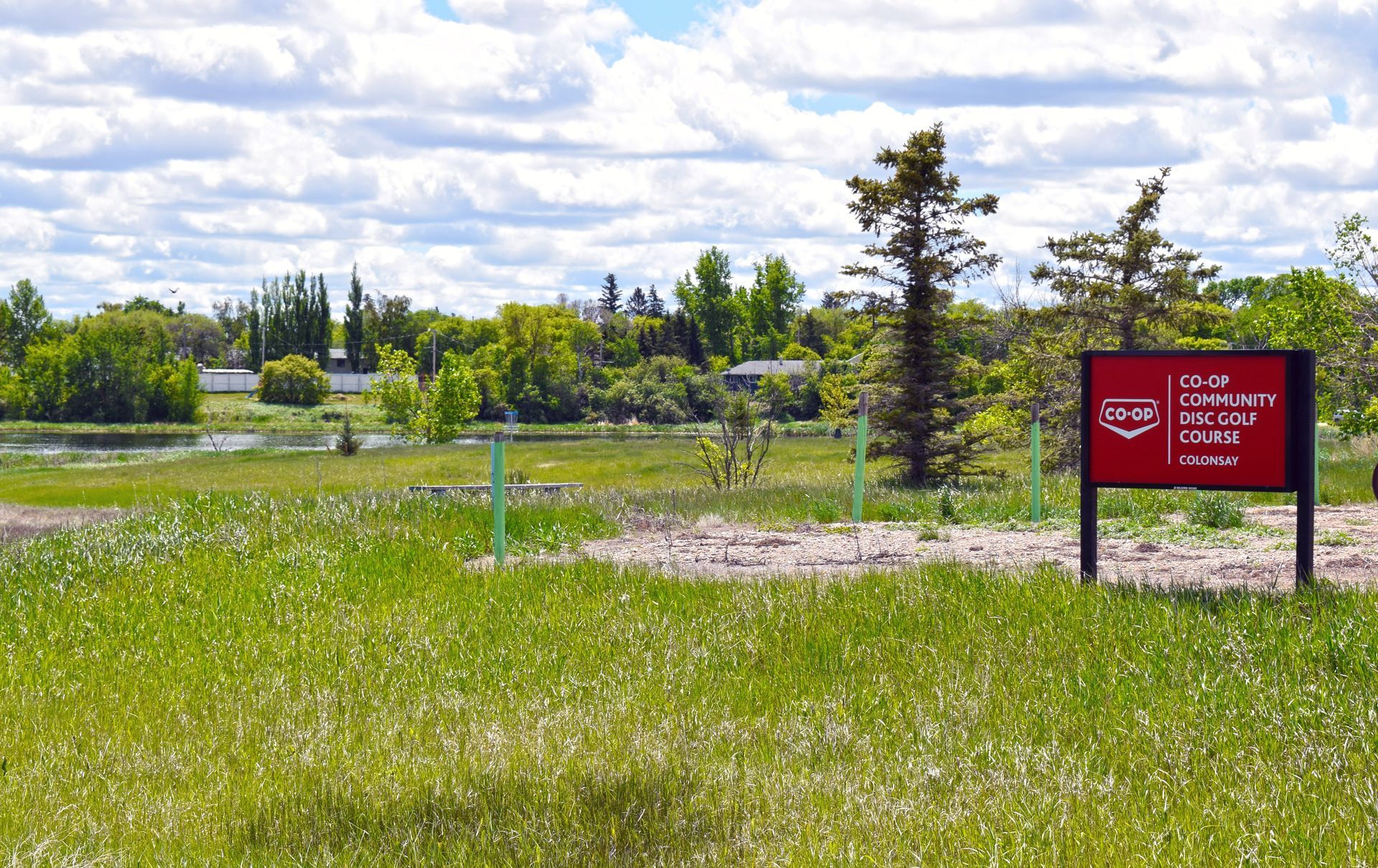 Co-op sign is sitting in the middle of a Disc Golf field.
