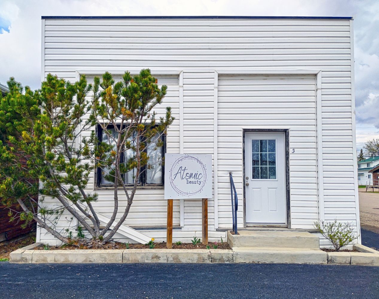 A white building with a sign in front of it.