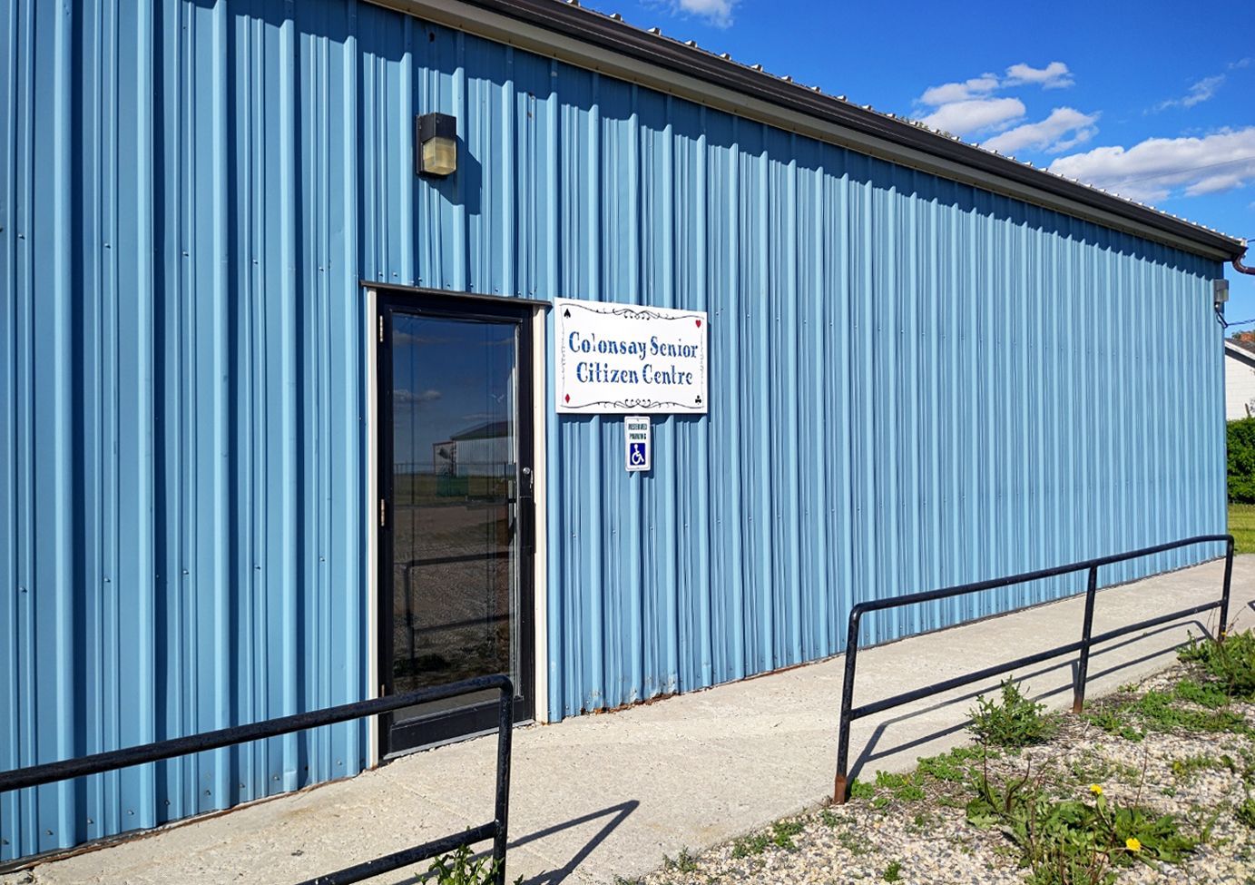 A blue building with a handicapped ramp leading to the door.