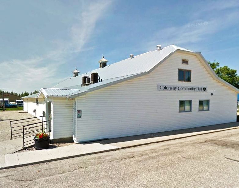 A white building with a sign that says coleman community hall