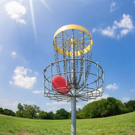 A frisbee golf basket with a red frisbee in it