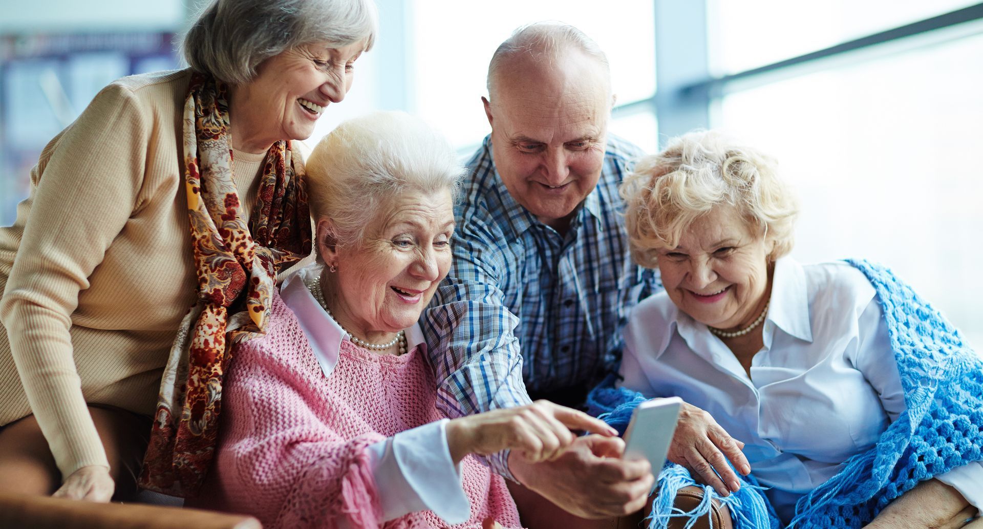 A nurse is talking to a group of elderly people in a living room.