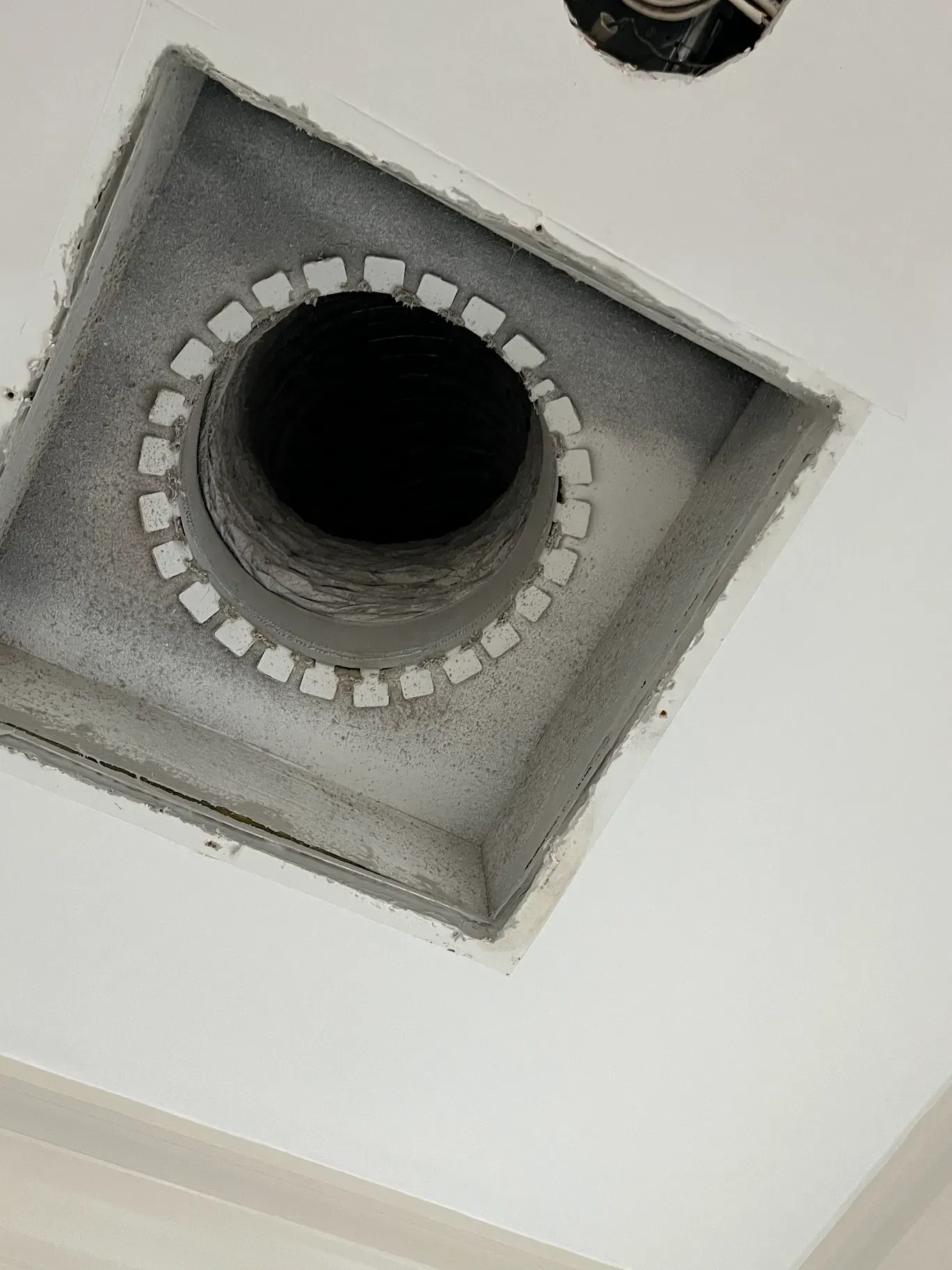 A square hole in the ceiling with a black hole in the middle.