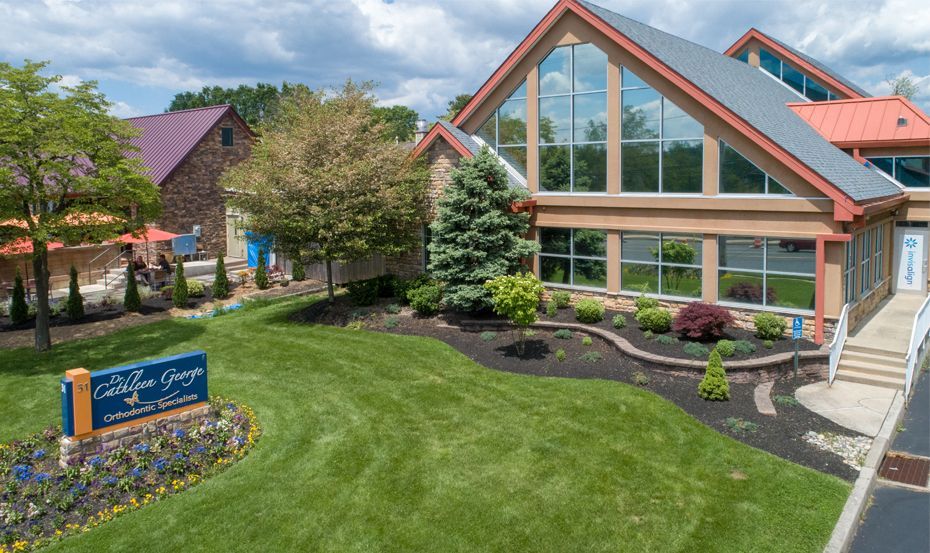 An aerial view of a large building with a lot of windows and a sign in front of it.