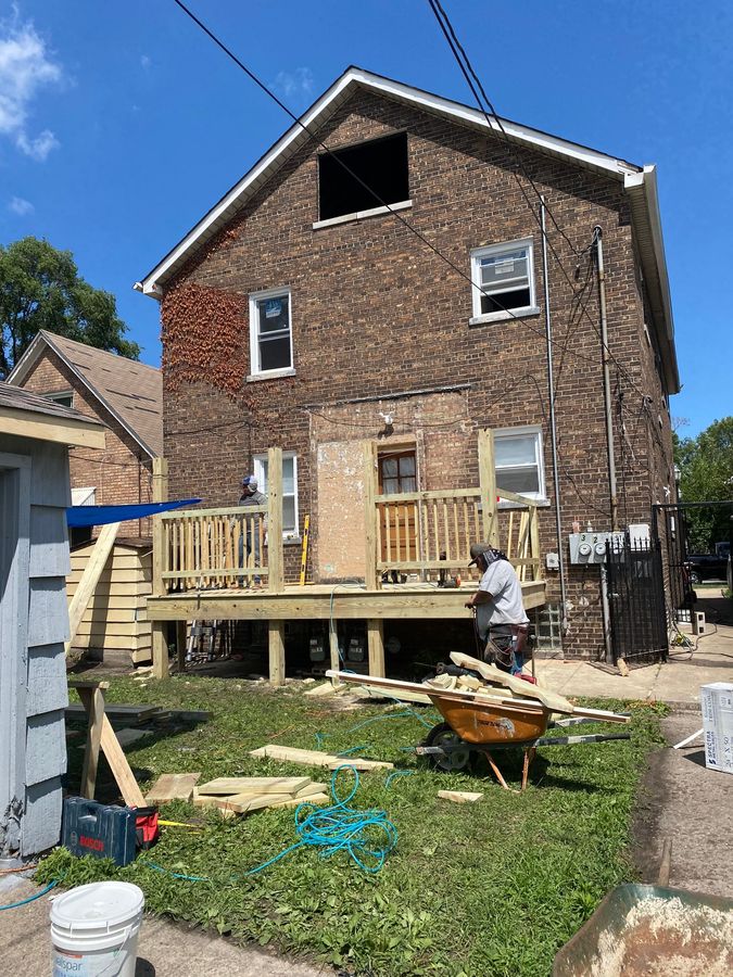 Construction workers building a porch behind a home