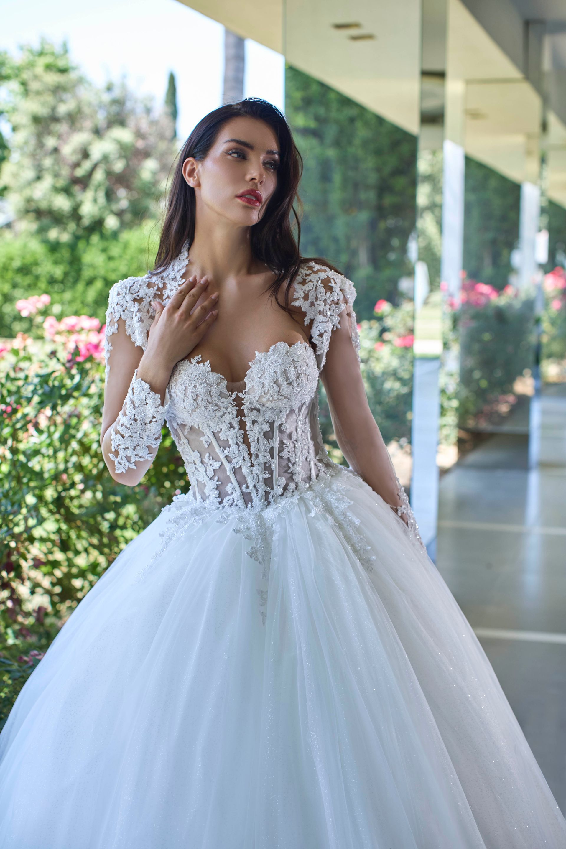 Donna in abito da ballo bianco, corpetto di pizzo, in posa all'aperto.