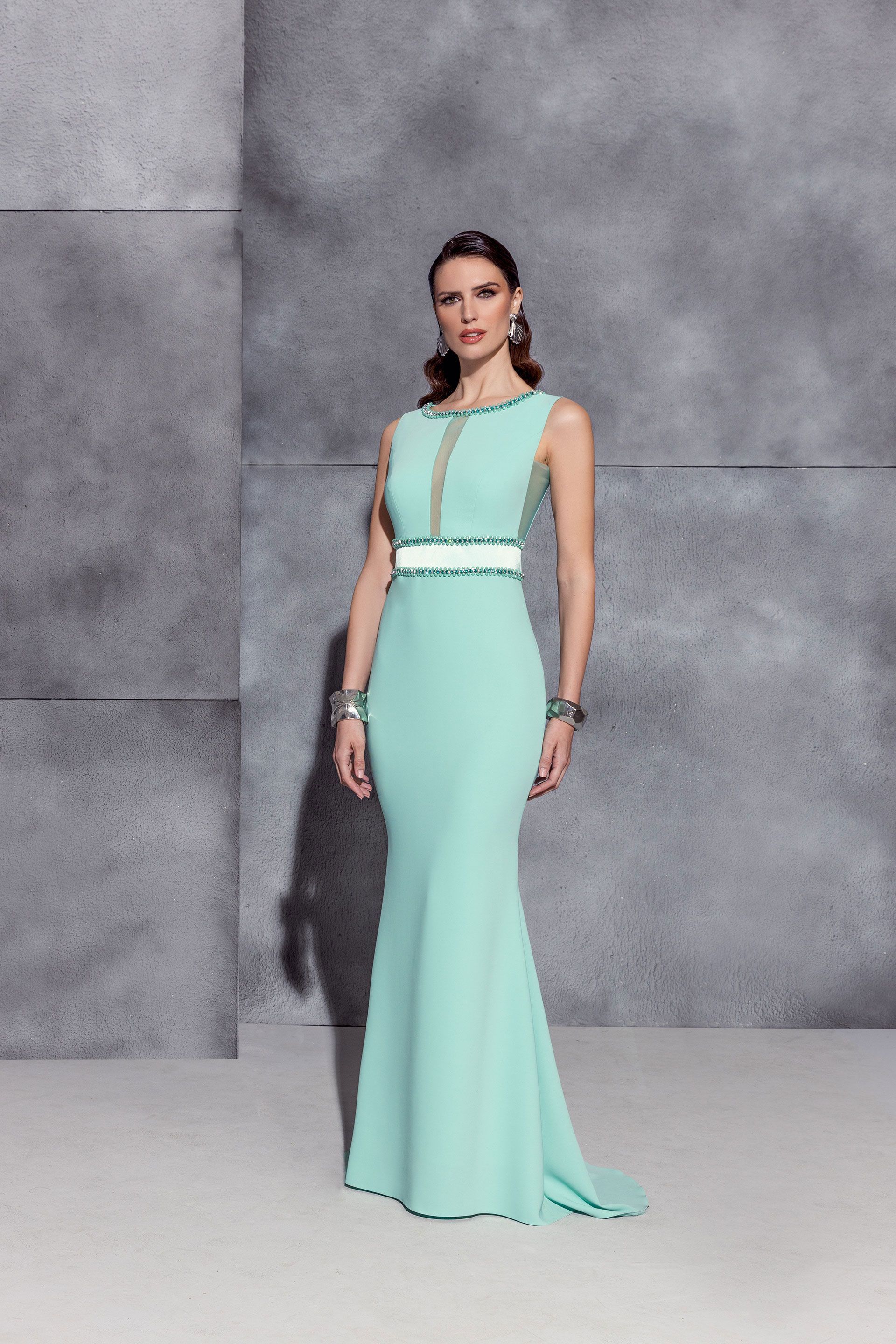 Donna con abito a sirena verde menta con vita decorata di bianco.