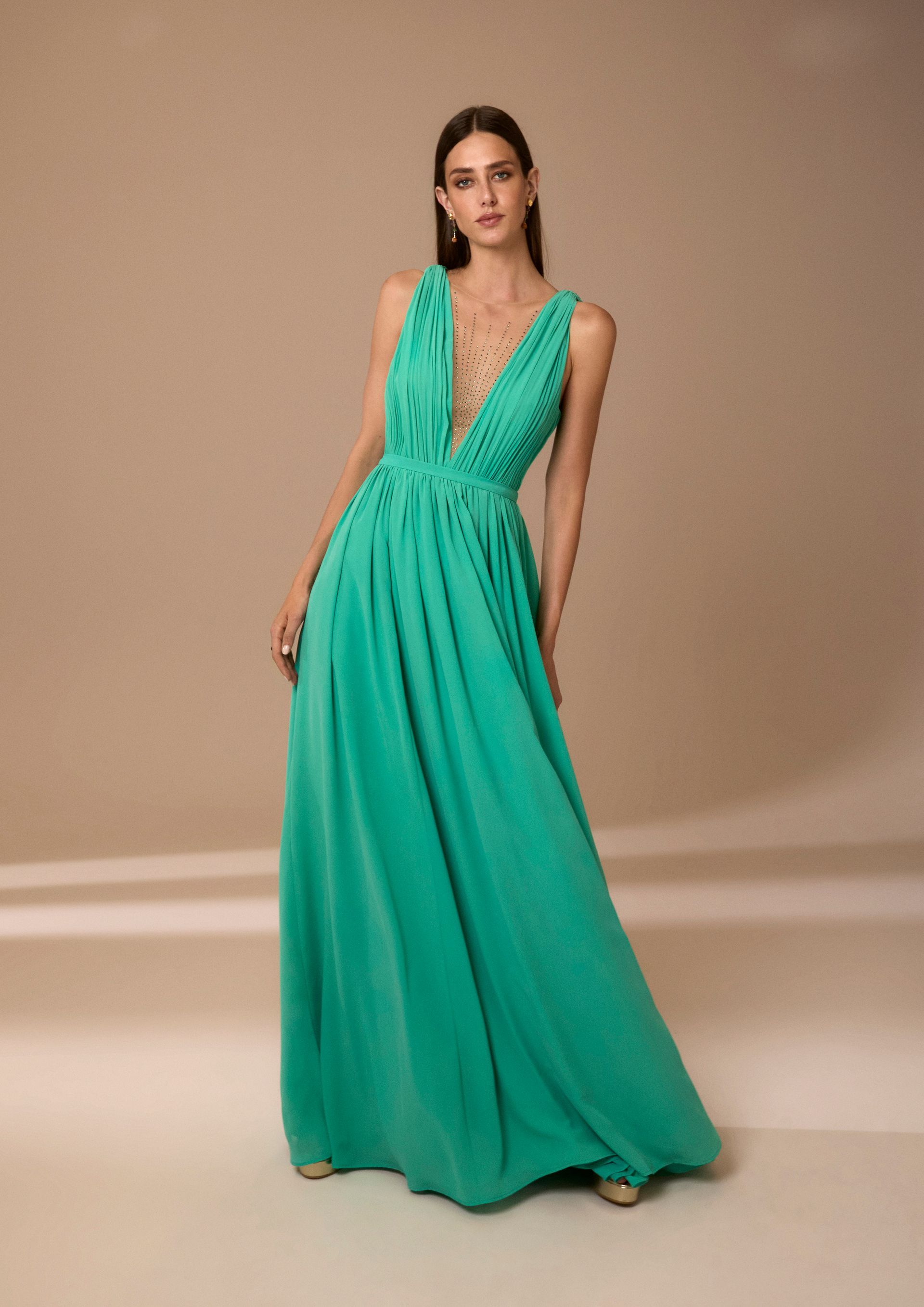 Donna con un abito turchese fluente con una profonda scollatura a V.