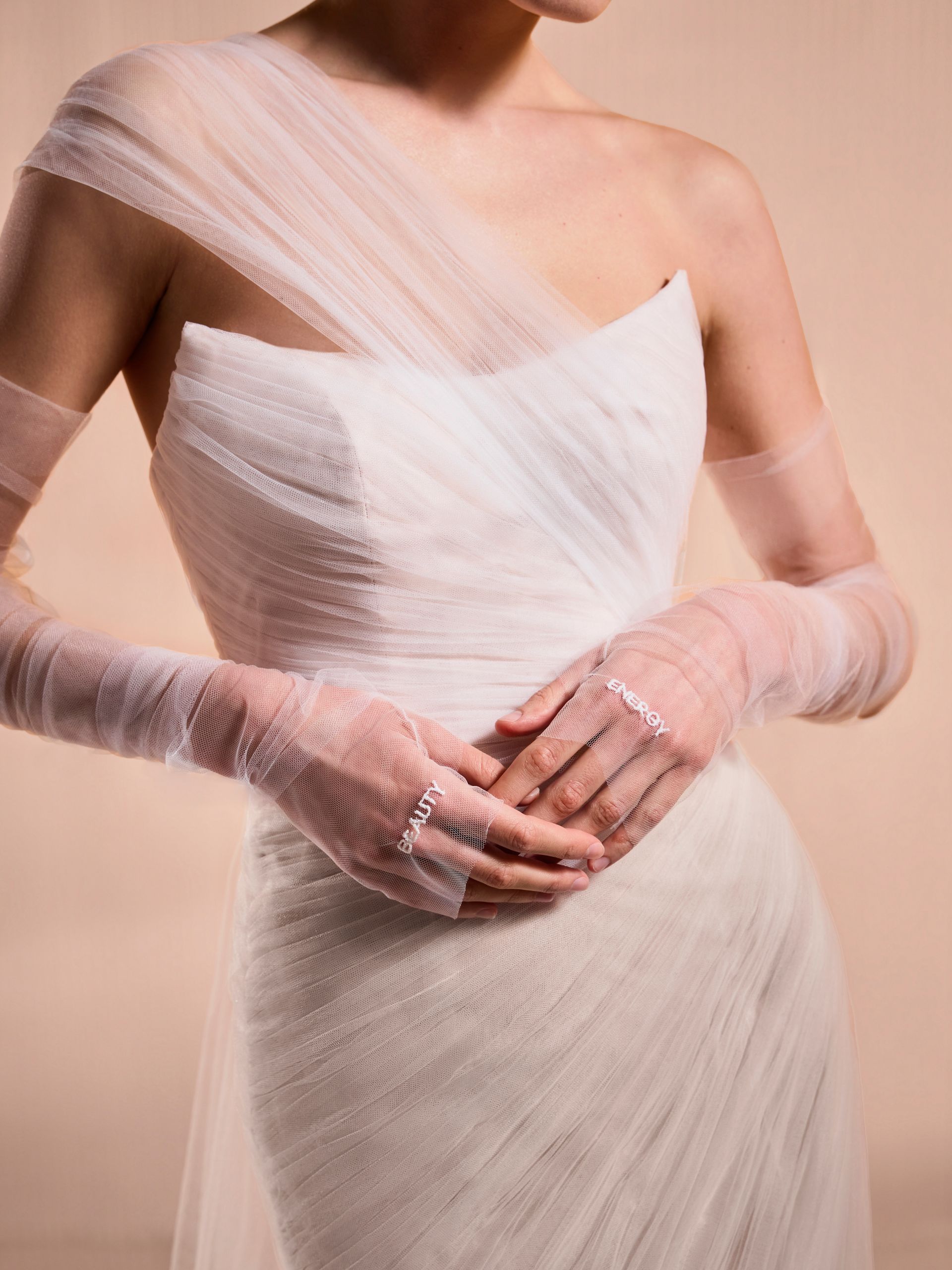 Donna in abito da sposa bianco con maniche trasparenti.