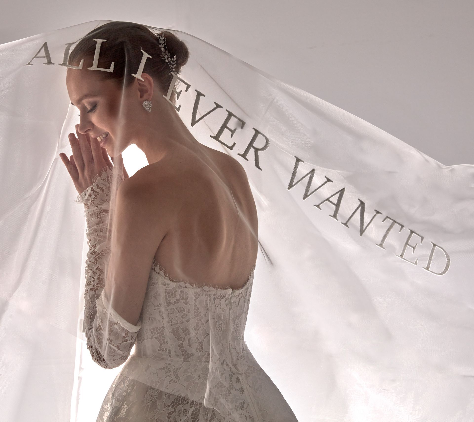 Donna in abito da sposa, con il velo che le copre il viso con la scritta 