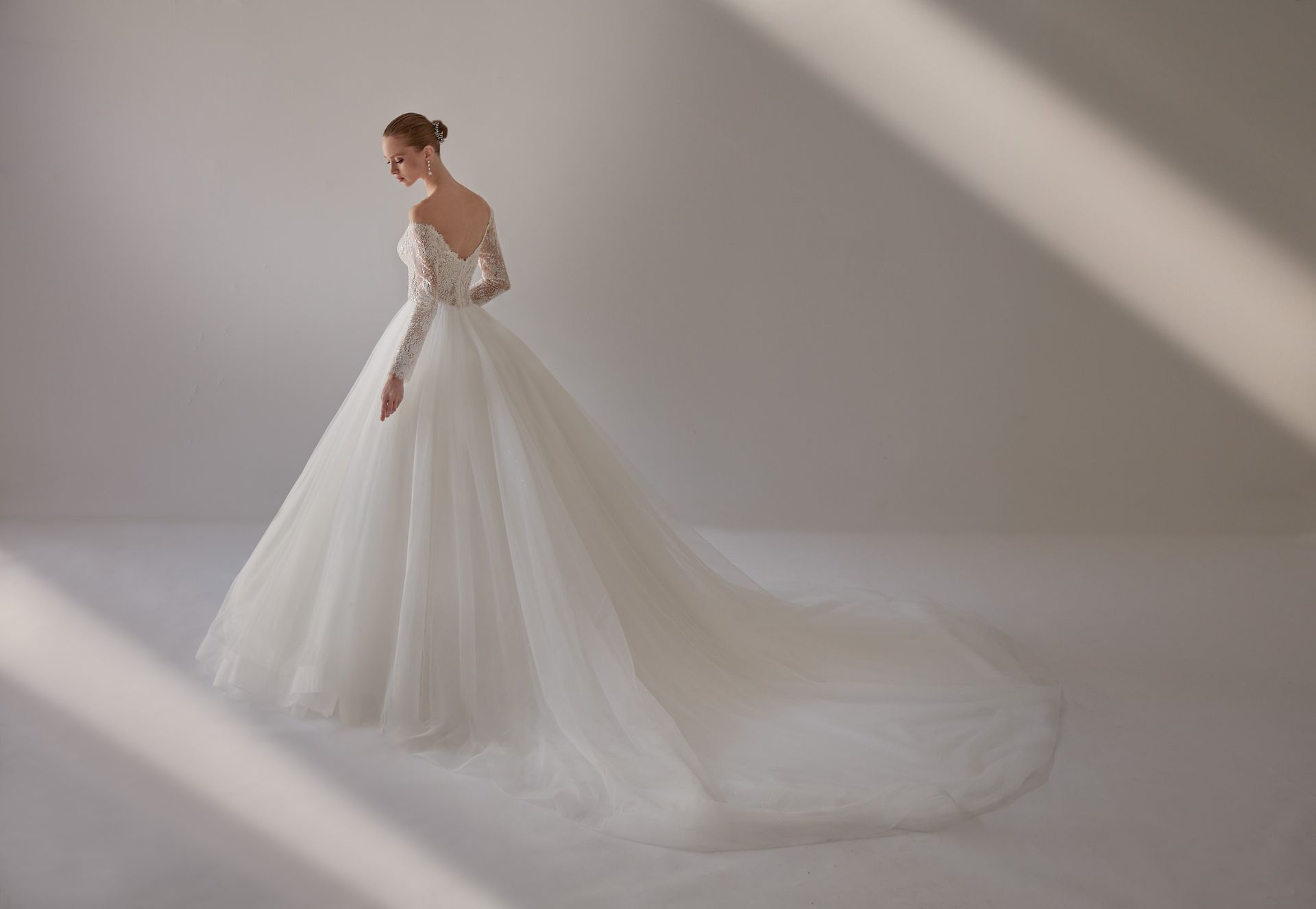 Donna in abito da sposa bianco con lungo strascico.