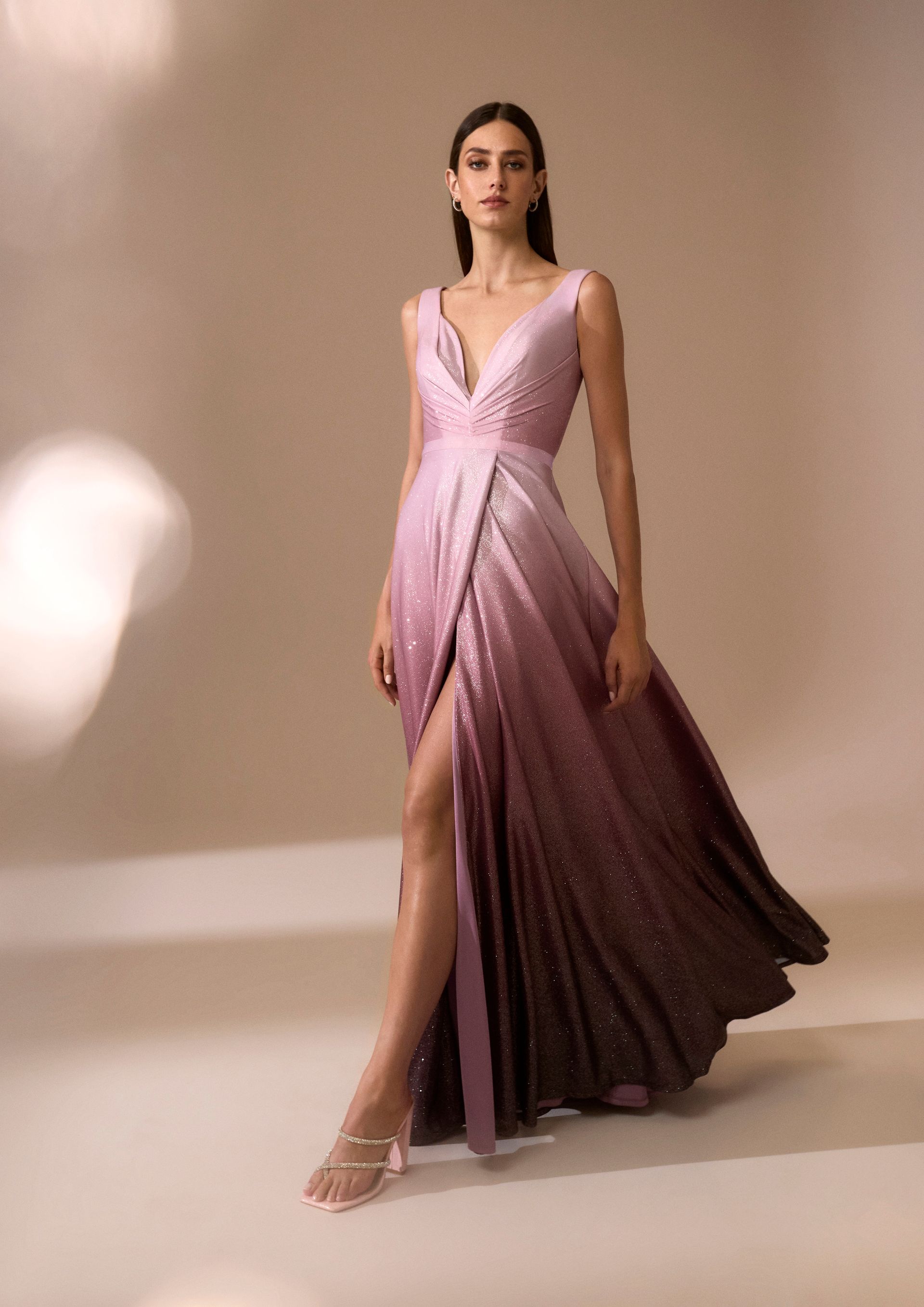 Donna con abito rosa sfumato con spacco profondo.