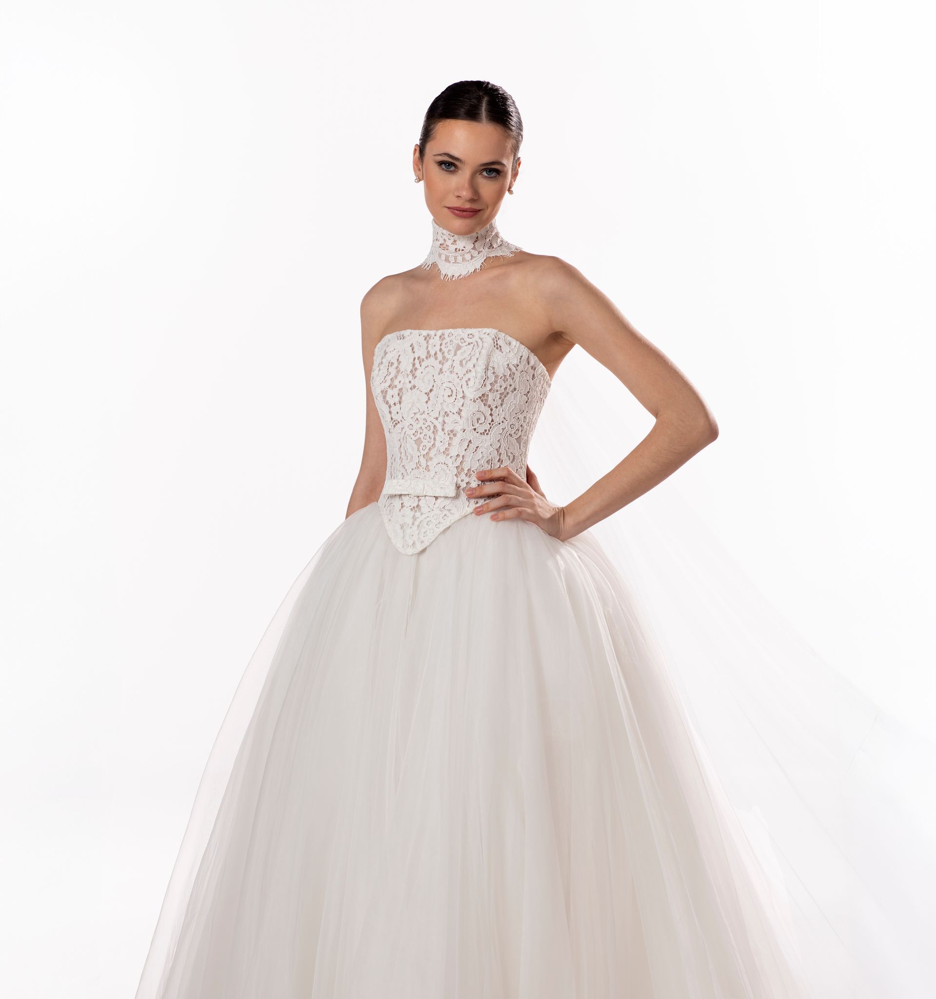 Donna che indossa un abito da sposa bianco senza spalline, con gonna ampia e corpetto in pizzo.