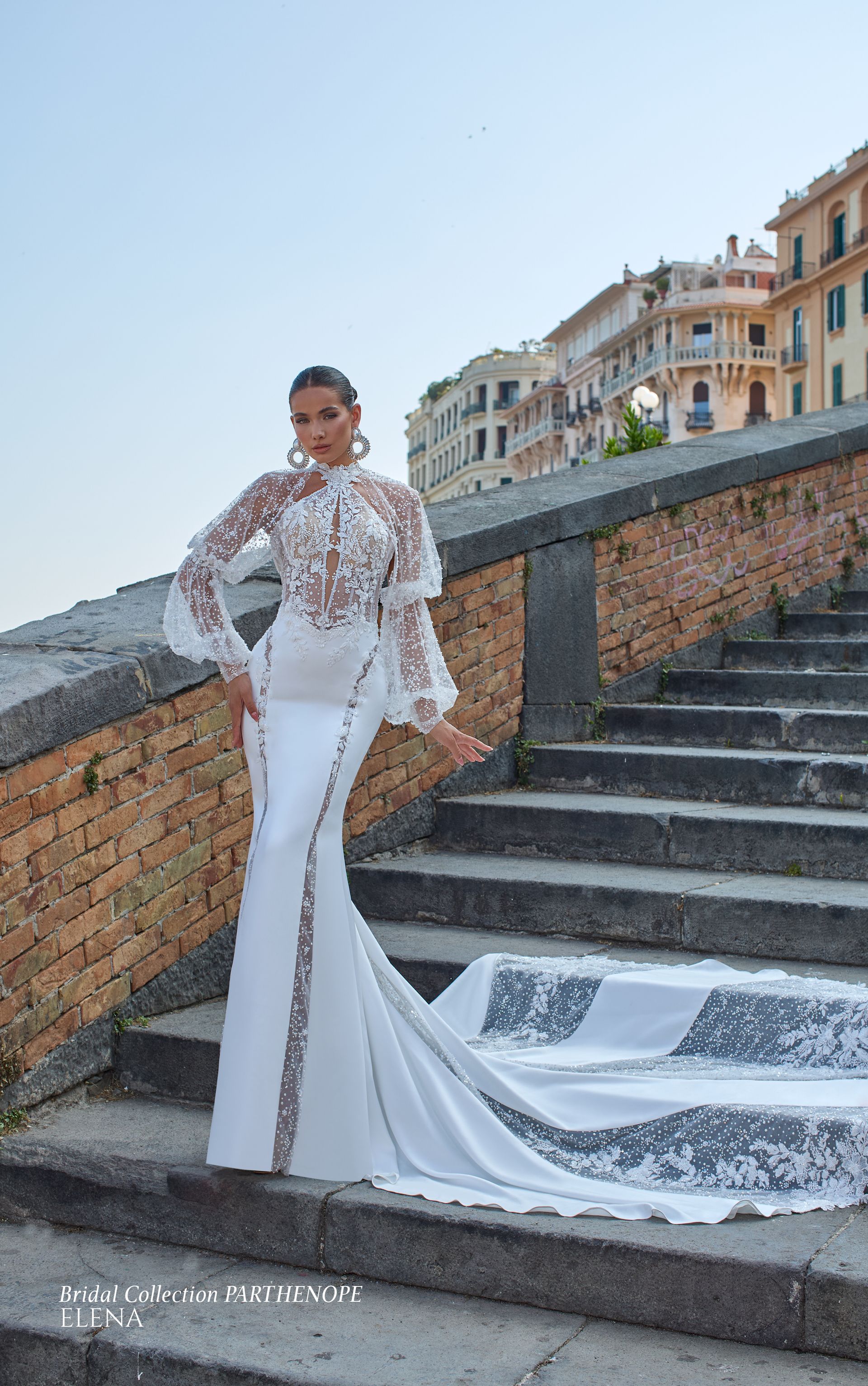 Donna in abito bianco su gradini di pietra; corpetto con collo alto e maniche lunghe, gonna a sirena con strascico