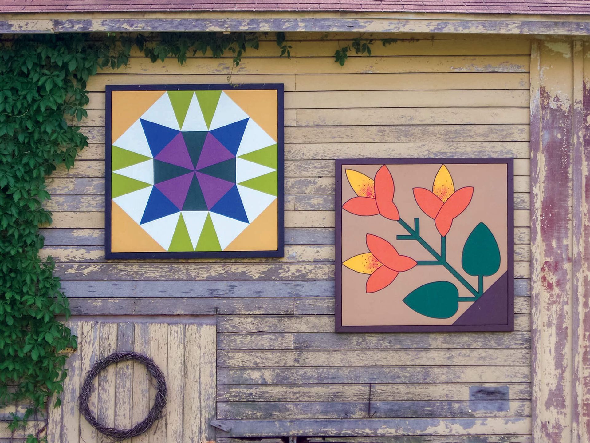 Two framed quilt squares on weathered barn siding; one geometric, the other floral.
