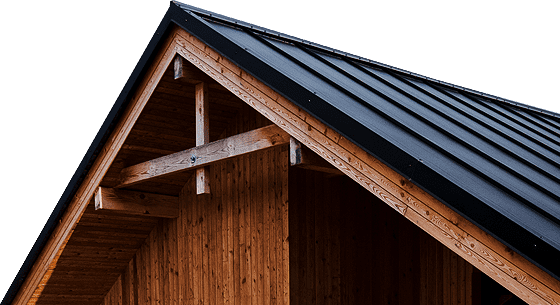 Wooden building with dark roof. Close-up of gable end, showing exposed rafters and support beams.