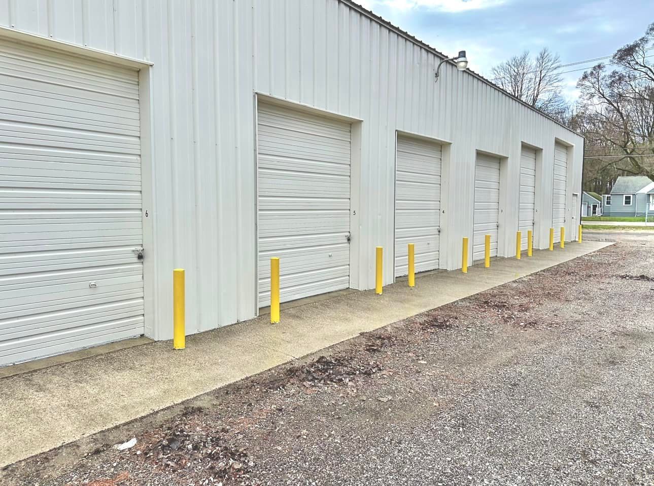 White storage units with yellow posts, in an outdoor lot.