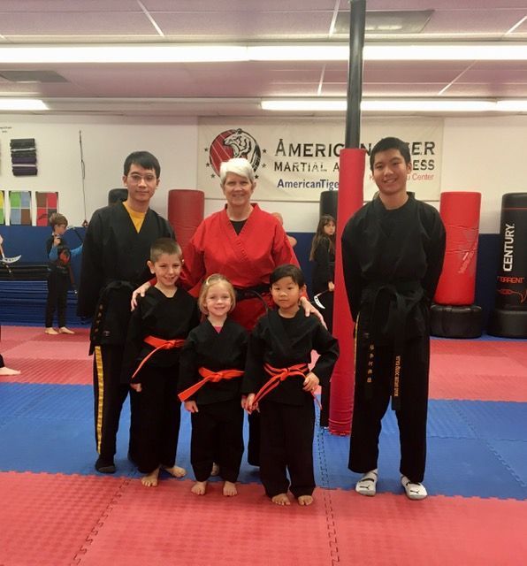 A group of people posing for a picture in a martial arts gym
