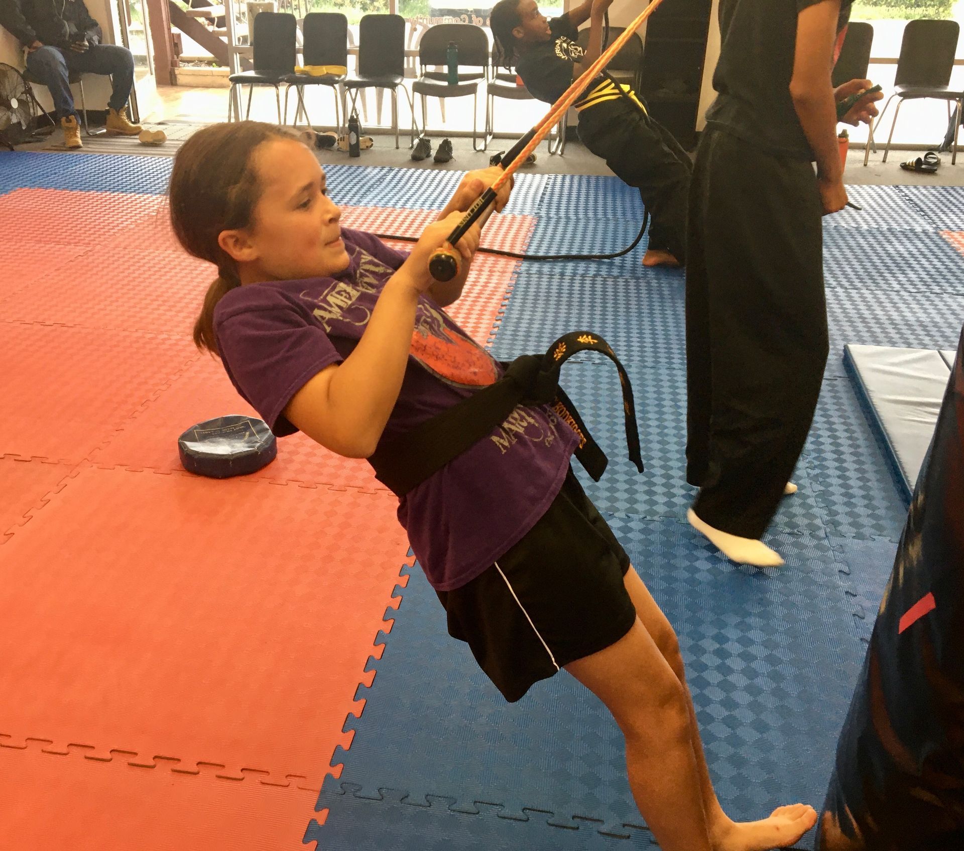 A girl doing circuit training - holding a rope and keeping balance