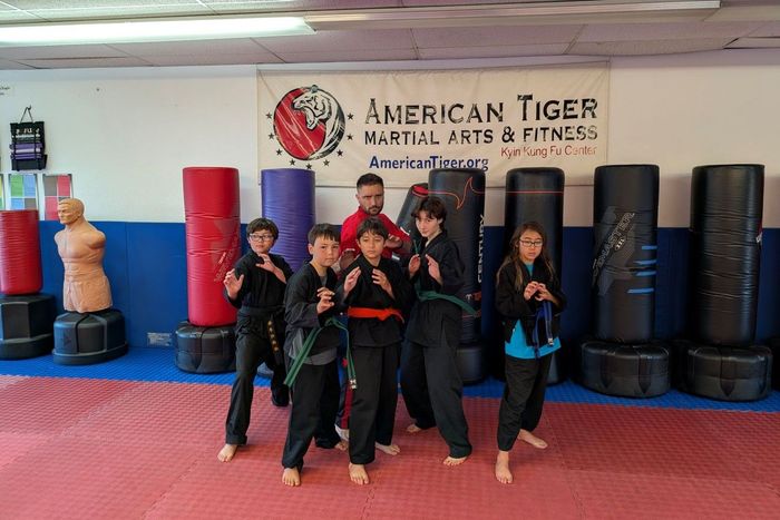 A group of children wearing face masks are posing for a picture.