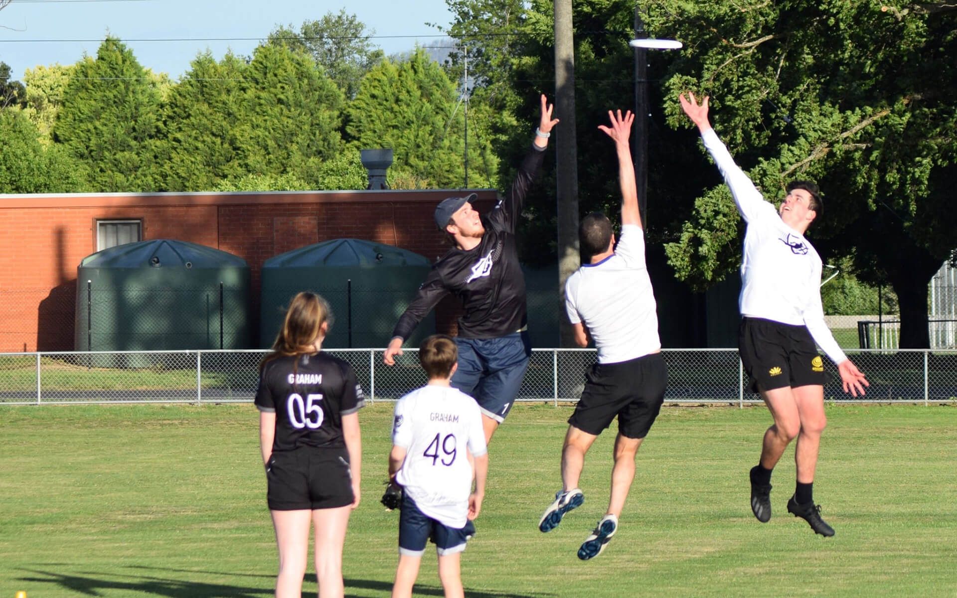 a group of people are playing frisbee on a field .