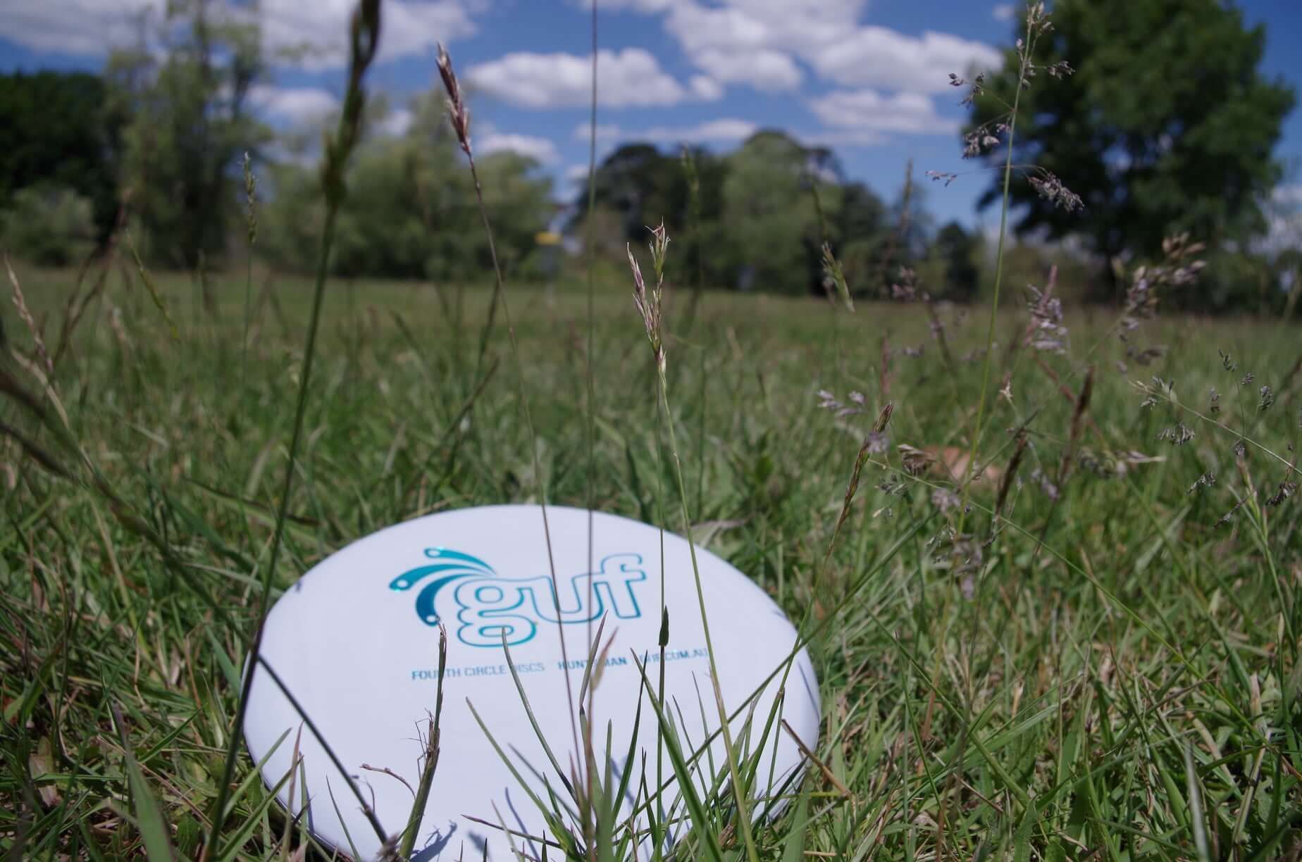 a frisbee with the word gulf on it is in the grass