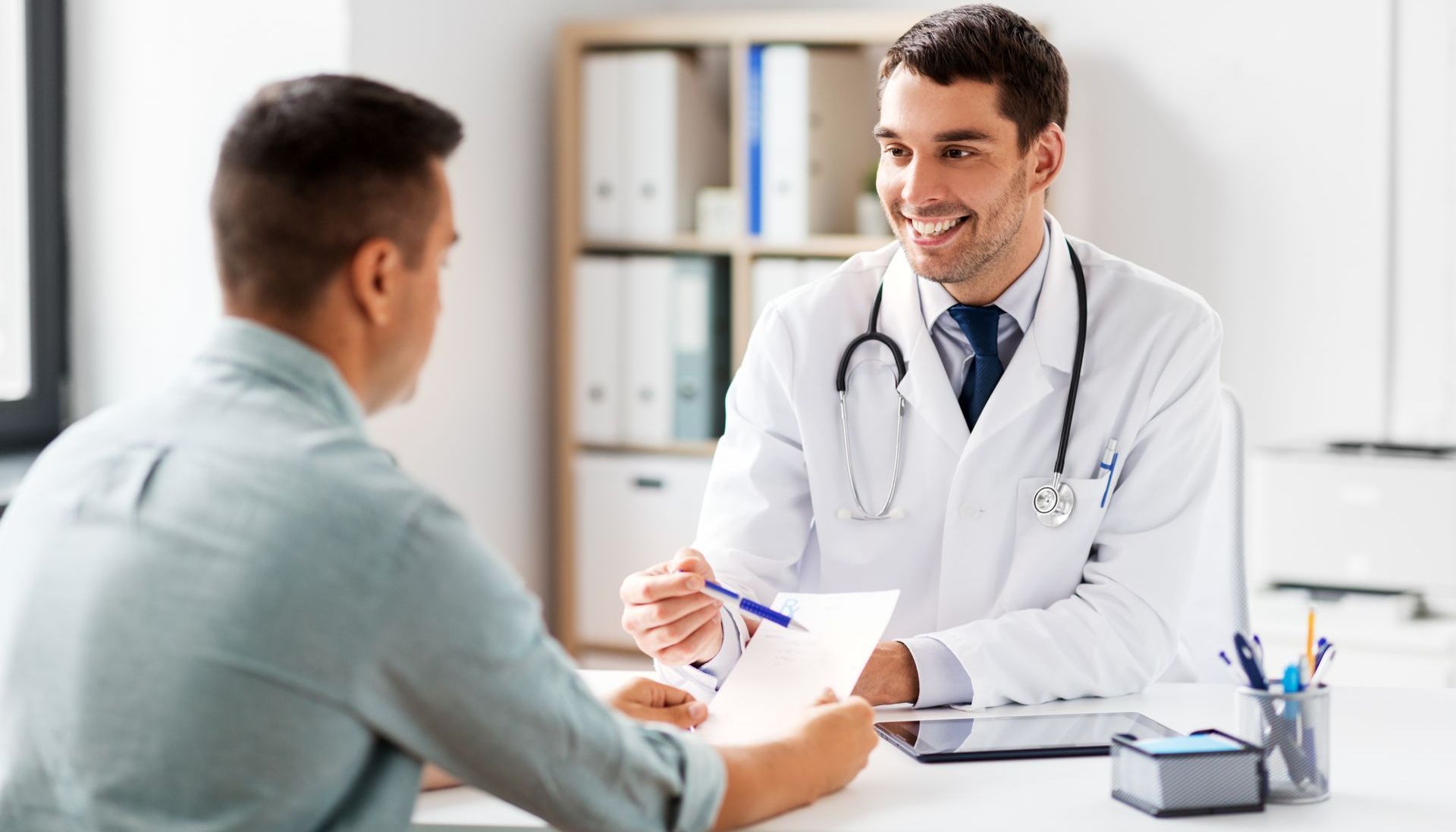 A doctor is talking to a patient in an office.