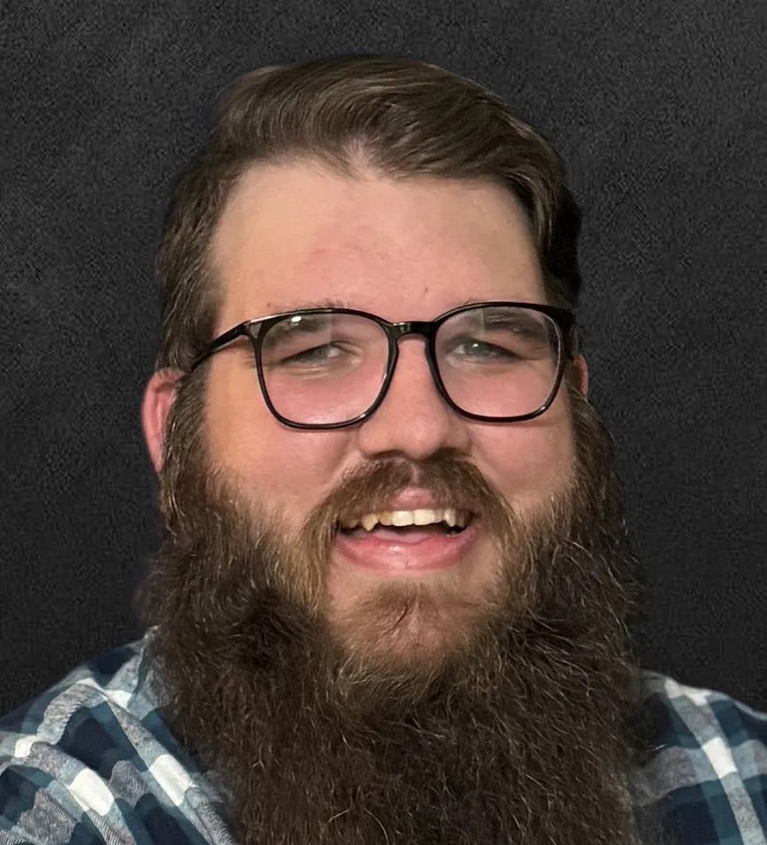 A man with a beard and glasses is smiling for the camera.