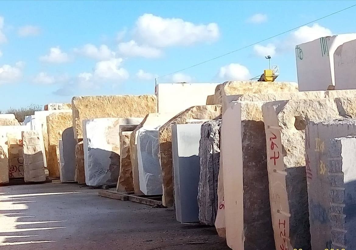 Un uomo con la barba è in piedi di fronte a un gruppo di uomini fermi davanti ai furgoni.