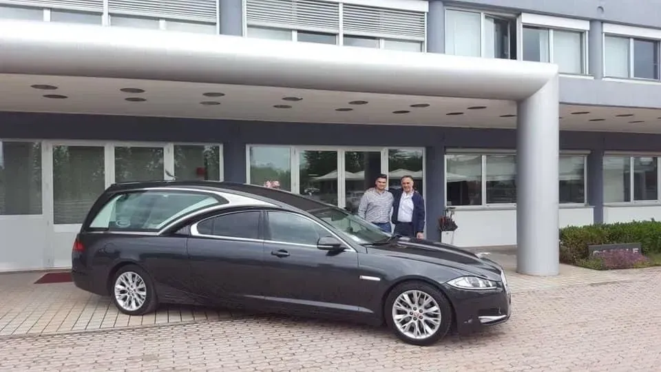 Un'auto nera è parcheggiata davanti a un edificio.