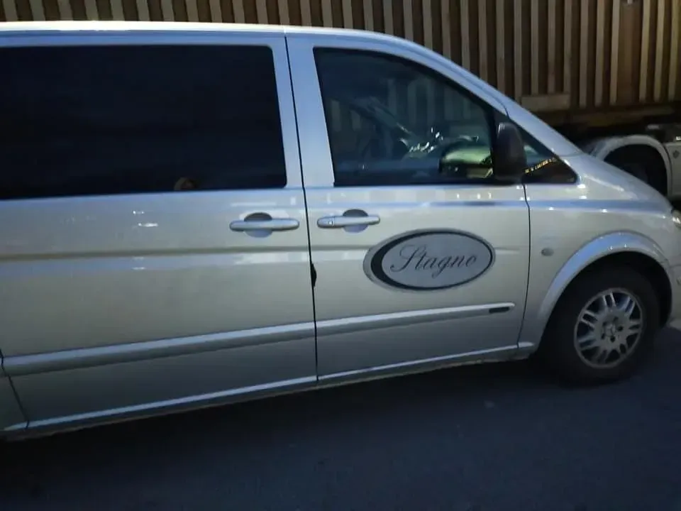 Un furgone argentato con la scritta stagno sul lato