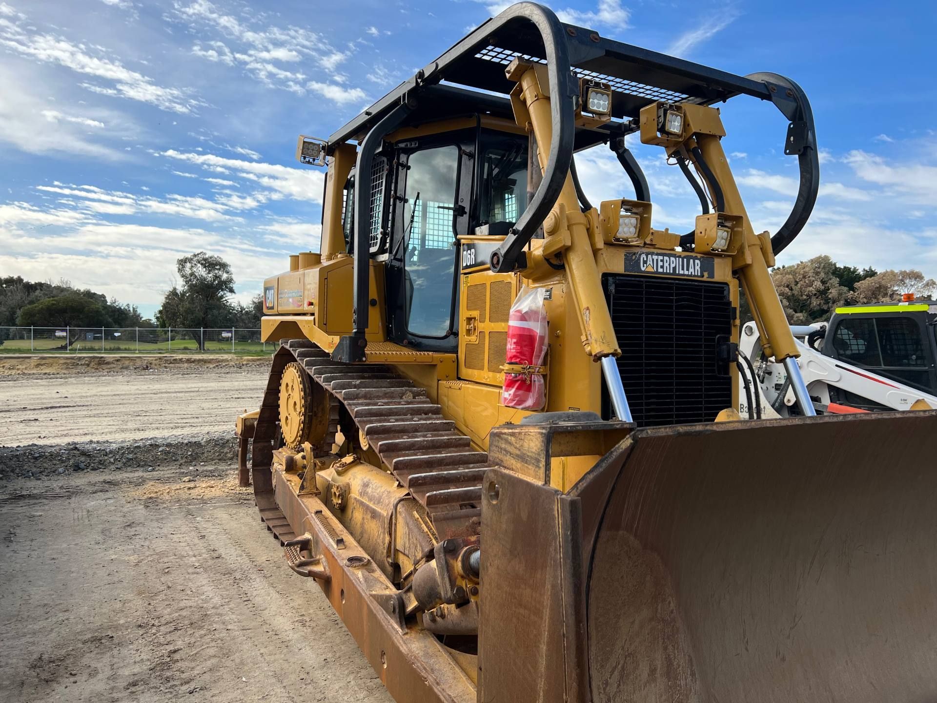 A bulldozer is parked in a dirt field.