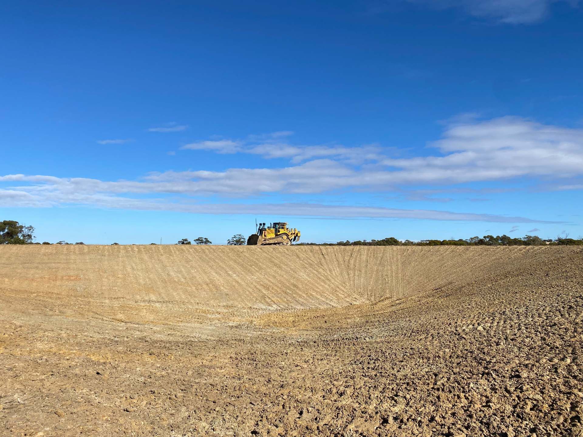 A tractor is plowing a field on a sunny day.