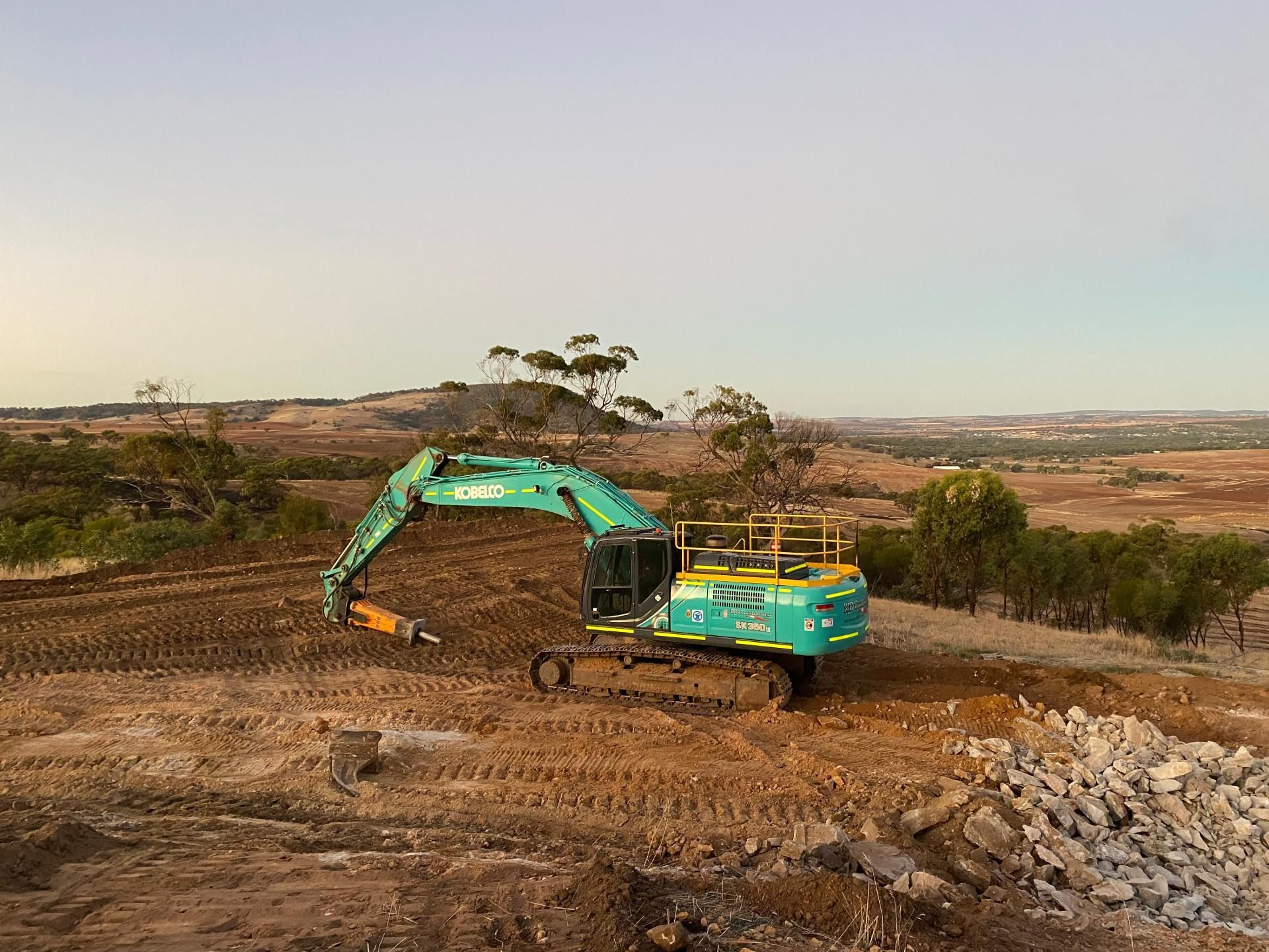 A large excavator is sitting on top of a dirt field.