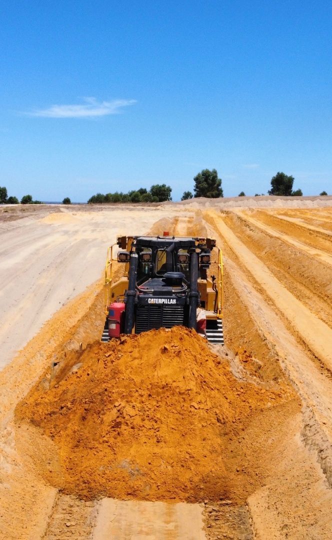 A bulldozer is driving down a dirt road.
